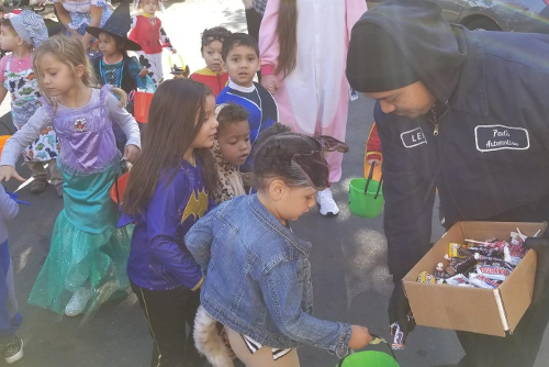 Handing out Halloween candy to the local preschoolers, outside the shop